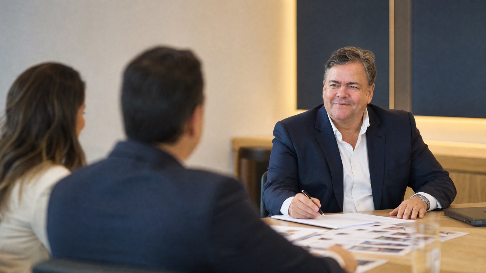 Marco Amaral em reunião de entrevista com dois profissionais em sala clara